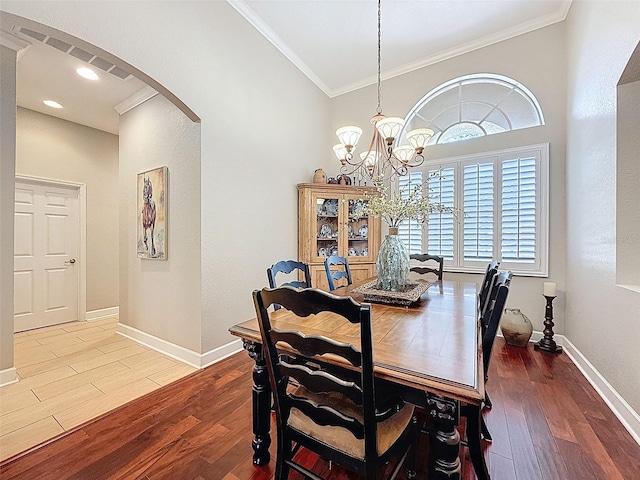13248 Linzia Ln, Spring Hill, FL 34609 - dining area featuring arched walkways, crown molding, wood finished floors, a chandelier, and baseboards