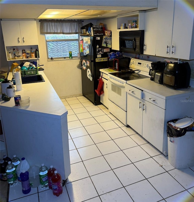 11726 Oceanside Dr, Port Richey, FL 34668 - kitchen featuring black appliances, light tile patterned floors, light countertops, and white cabinetry