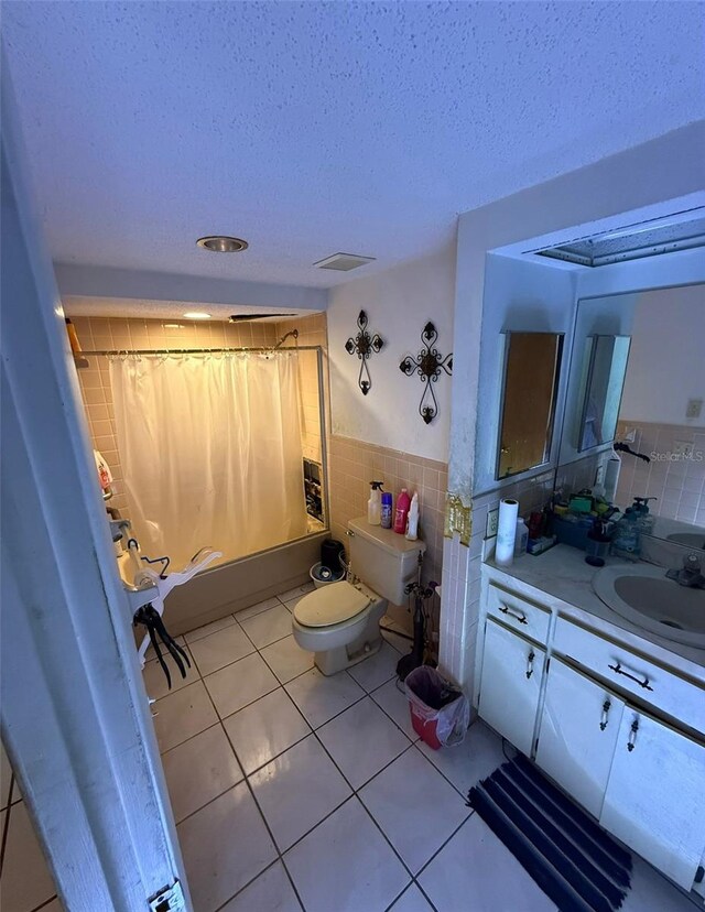 11726 Oceanside Dr, Port Richey, FL 34668 - bathroom with tile walls, toilet, vanity, tile patterned flooring, and shower / bath combo
