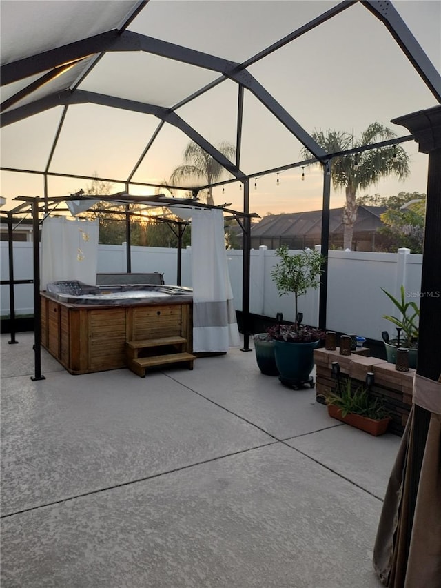 9967 Patrician Dr, New Port Richey, FL 34655 - patio terrace at dusk with a hot tub, a patio area, and a lanai