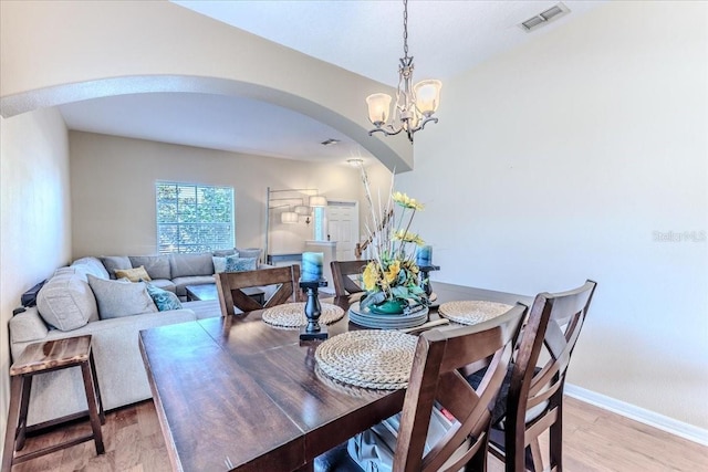 4094 Braemere Dr, Spring Hill, FL 34609 - dining area with arched walkways, light wood-type flooring, a chandelier, and baseboards