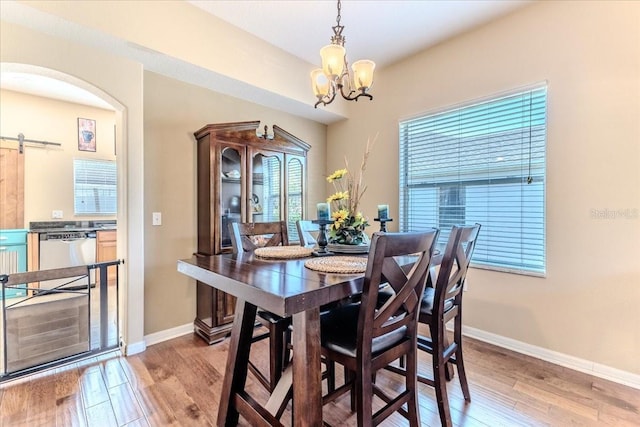 4094 Braemere Dr, Spring Hill, FL 34609 - dining space with a chandelier, light wood-style flooring, arched walkways, and baseboards
