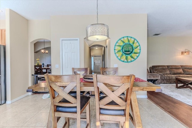 4094 Braemere Dr, Spring Hill, FL 34609 - dining room with arched walkways, light tile patterned flooring, baseboards, and a chandelier