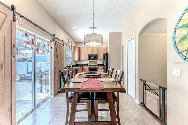 4094 Braemere Dr, Spring Hill, FL 34609 - dining space with a barn door, light tile patterned flooring, arched walkways, and a textured ceiling