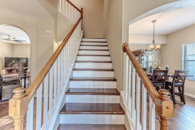 4094 Braemere Dr, Spring Hill, FL 34609 - stairs with arched walkways, wood finished floors, ceiling fan, a chandelier, and baseboards