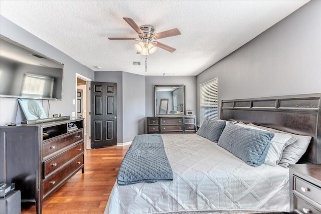 4094 Braemere Dr, Spring Hill, FL 34609 - bedroom featuring wood finished floors, a textured ceiling, and a ceiling fan