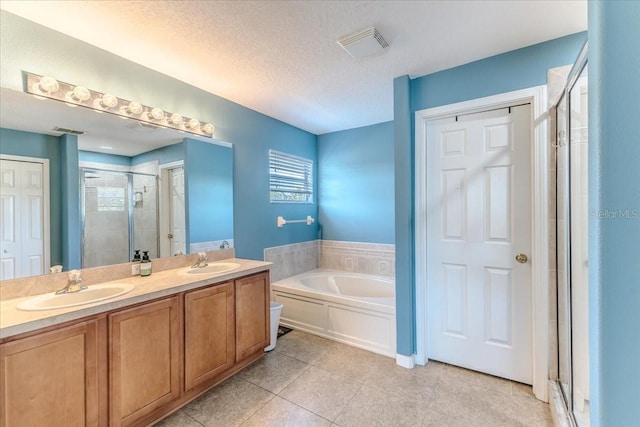 4094 Braemere Dr, Spring Hill, FL 34609 - bathroom featuring a shower stall, a garden tub, double vanity, tile patterned flooring, and a textured ceiling