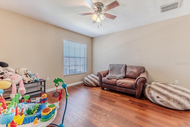 4094 Braemere Dr, Spring Hill, FL 34609 - game room featuring a ceiling fan, wood finished floors, baseboards, and a textured ceiling
