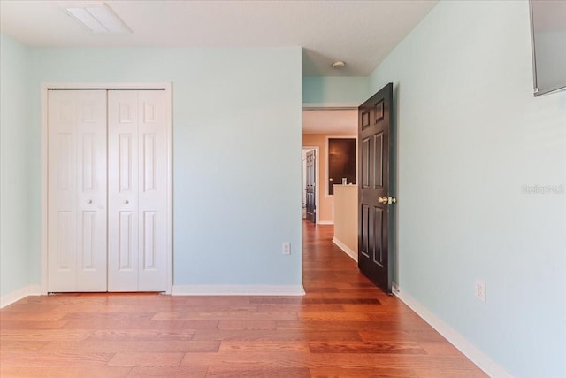 4094 Braemere Dr, Spring Hill, FL 34609 - unfurnished bedroom featuring wood finished floors, a closet, and baseboards