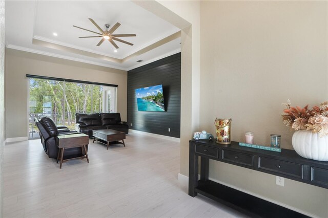 10380 Yellow Hammer Rd, Weeki Wachee, FL 34614 - living room featuring a tray ceiling, baseboards, ceiling fan, light wood-style floors, and ornamental molding