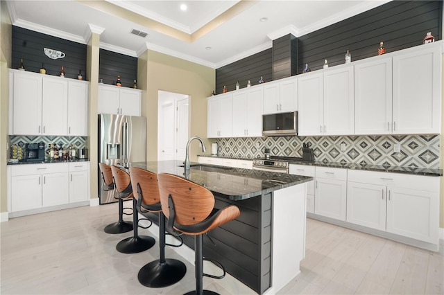 10380 Yellow Hammer Rd, Weeki Wachee, FL 34614 - kitchen with stainless steel appliances, a sink, tasteful backsplash, white cabinets, and ornamental molding