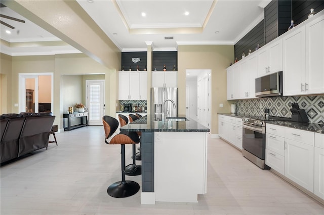 10380 Yellow Hammer Rd, Weeki Wachee, FL 34614 - kitchen with stainless steel appliances, a raised ceiling, a sink, a kitchen breakfast bar, and tasteful backsplash