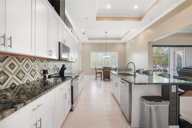 10380 Yellow Hammer Rd, Weeki Wachee, FL 34614 - kitchen featuring a sink, stainless steel appliances, a kitchen breakfast bar, backsplash, and a raised ceiling