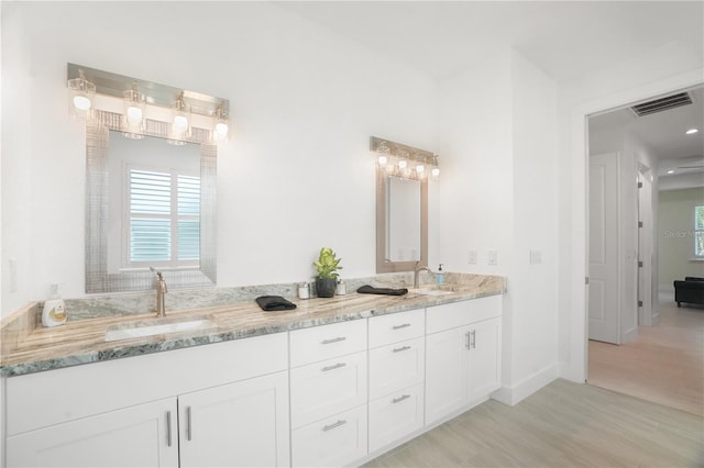 10380 Yellow Hammer Rd, Weeki Wachee, FL 34614 - full bath featuring wood finished floors, double vanity, and baseboards