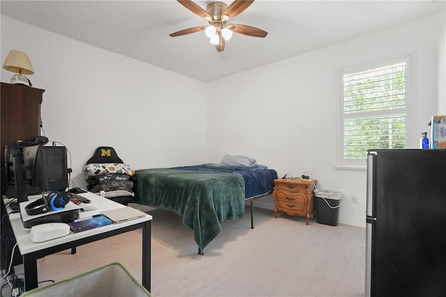 10380 Yellow Hammer Rd, Weeki Wachee, FL 34614 - bedroom featuring freestanding refrigerator, light wood finished floors, and a ceiling fan