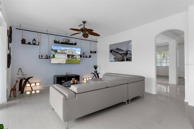 4215 Maplehurst Way, Spring Hill, FL 34609 - living room featuring arched walkways, ceiling fan, light tile patterned floors, and baseboards
