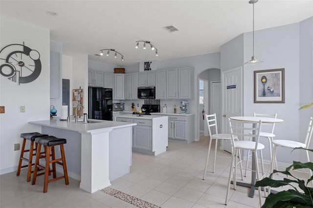 4215 Maplehurst Way, Spring Hill, FL 34609 - kitchen featuring stainless steel microwave, freestanding refrigerator, a sink, a peninsula, and a breakfast bar