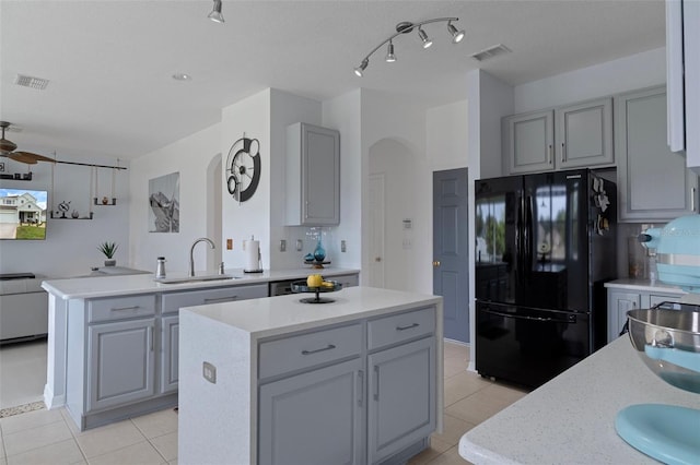 4215 Maplehurst Way, Spring Hill, FL 34609 - kitchen featuring freestanding refrigerator, gray cabinetry, a sink, arched walkways, and a center island