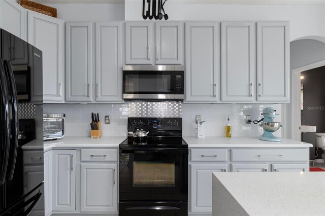 4215 Maplehurst Way, Spring Hill, FL 34609 - kitchen featuring black appliances, light countertops, backsplash, and white cabinetry