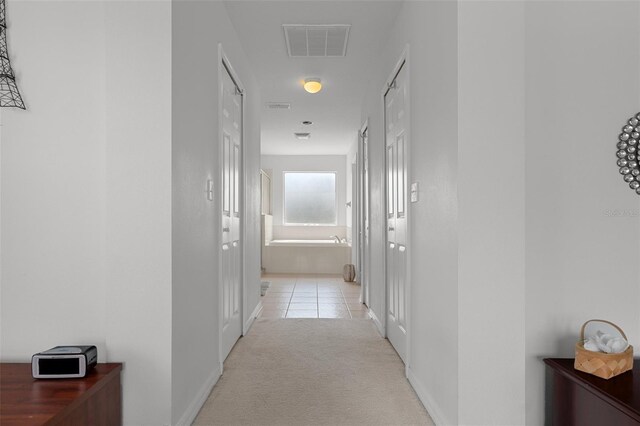 4215 Maplehurst Way, Spring Hill, FL 34609 - hallway featuring light carpet, baseboards, and light tile patterned floors