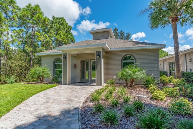 4215 Maplehurst Way, Spring Hill, FL 34609 - view of front of property featuring french doors, a shingled roof, and a front yard