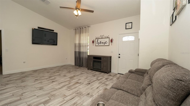 12458 Fish Cove Dr, Spring Hill, FL 34609 - living room with light wood-style floors, vaulted ceiling, a ceiling fan, a fireplace, and baseboards