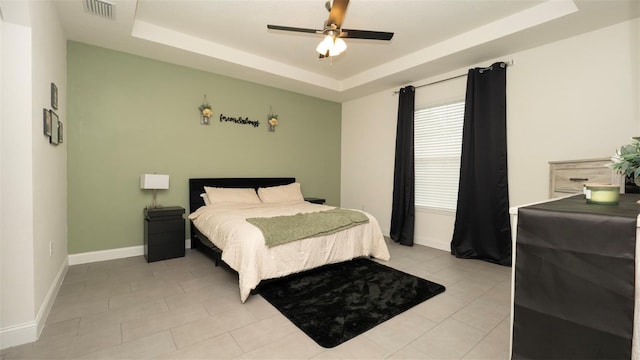 12458 Fish Cove Dr, Spring Hill, FL 34609 - bedroom with a tray ceiling, baseboards, light tile patterned flooring, and a ceiling fan