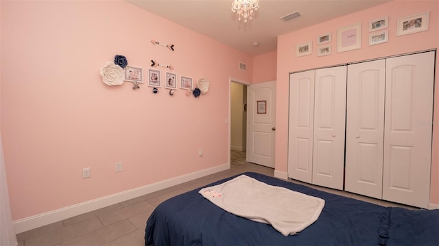 12458 Fish Cove Dr, Spring Hill, FL 34609 - tiled bedroom with a closet, baseboards, and a chandelier