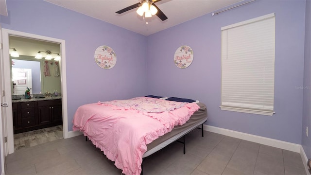 12458 Fish Cove Dr, Spring Hill, FL 34609 - bedroom featuring light tile patterned flooring, baseboards, ensuite bathroom, and ceiling fan