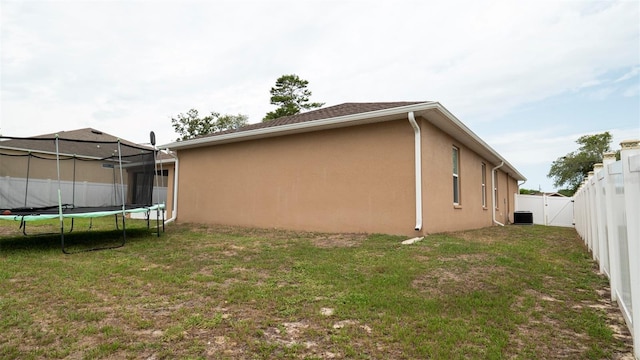 12458 Fish Cove Dr, Spring Hill, FL 34609 - view of side of property featuring a trampoline, stucco siding, and central AC