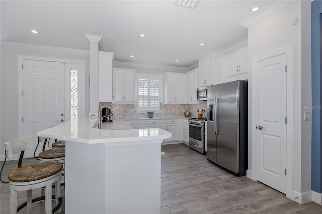 3051 Francoa Dr, Odessa, FL 33556 - kitchen with stainless steel appliances, a sink, a peninsula, a breakfast bar, and crown molding