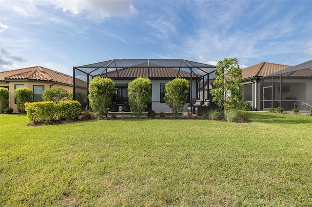 3051 Francoa Dr, Odessa, FL 33556 - rear view of property featuring a tiled roof, a lawn, stucco siding, and glass enclosure