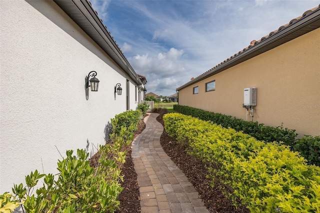 3051 Francoa Dr, Odessa, FL 33556 - view of side of property with stucco siding and water heater