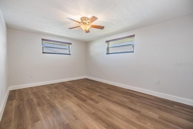 4468 Rudder Way, New Port Richey, FL 34652 - unfurnished room with healthy amount of natural light, baseboards, wood finished floors, and a textured ceiling