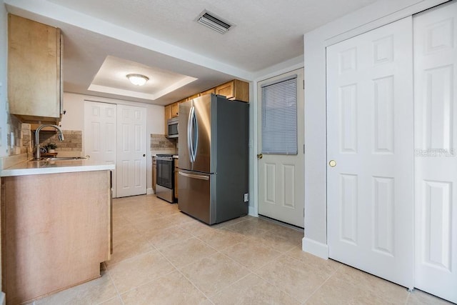 4468 Rudder Way, New Port Richey, FL 34652 - kitchen featuring stainless steel appliances, a sink, a tray ceiling, light countertops, and tasteful backsplash