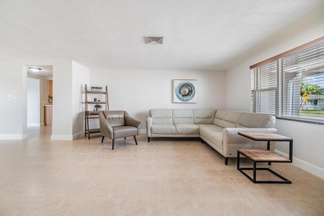 4468 Rudder Way, New Port Richey, FL 34652 - living room featuring a textured ceiling, light tile patterned floors, and baseboards