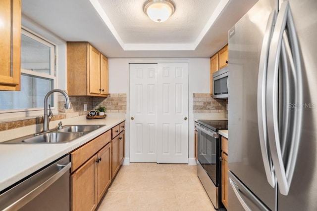 4468 Rudder Way, New Port Richey, FL 34652 - kitchen with appliances with stainless steel finishes, a sink, a tray ceiling, decorative backsplash, and light countertops
