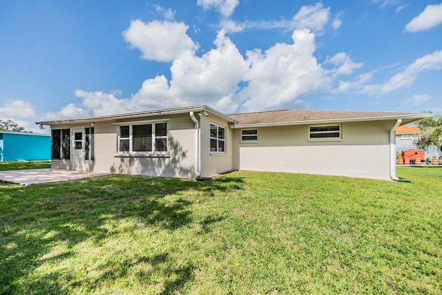 4468 Rudder Way, New Port Richey, FL 34652 - rear view of house featuring stucco siding, a patio area, and a lawn
