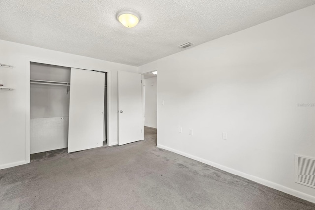 12936 Parkwood St, Hudson, FL 34669 - unfurnished bedroom featuring a textured ceiling, carpet flooring, a closet, and baseboards
