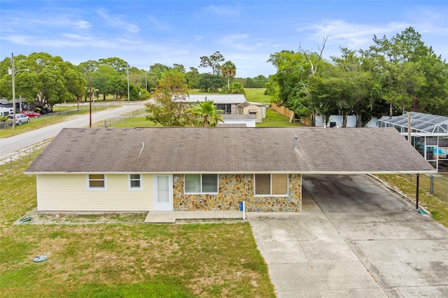 12936 Parkwood St, Hudson, FL 34669 - ranch-style home featuring concrete driveway, a carport, stone siding, and a front yard