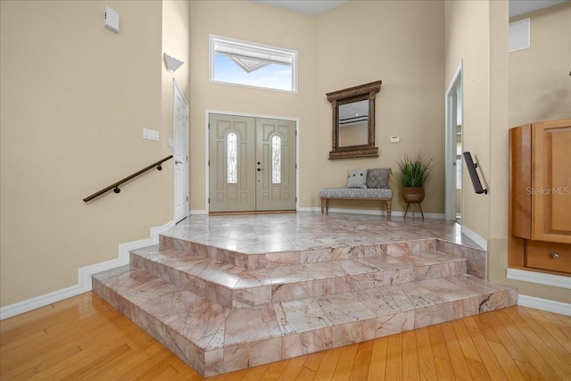 10044 Twelve Oaks Ct, Weeki Wachee, FL 34613 - foyer with a high ceiling, baseboards, light wood finished floors, and stairway