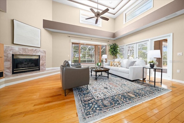 10044 Twelve Oaks Ct, Weeki Wachee, FL 34613 - living room featuring hardwood / wood-style flooring, ceiling fan, a towering ceiling, plenty of natural light, and a high end fireplace