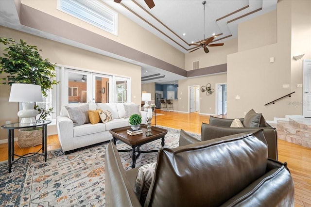 10044 Twelve Oaks Ct, Weeki Wachee, FL 34613 - living area with a ceiling fan, a towering ceiling, light wood-style floors, and baseboards