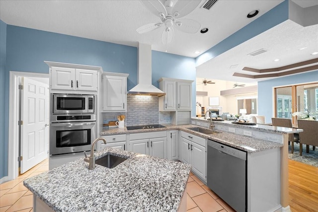 10044 Twelve Oaks Ct, Weeki Wachee, FL 34613 - kitchen with appliances with stainless steel finishes, ceiling fan, a sink, wall chimney exhaust hood, and a textured ceiling