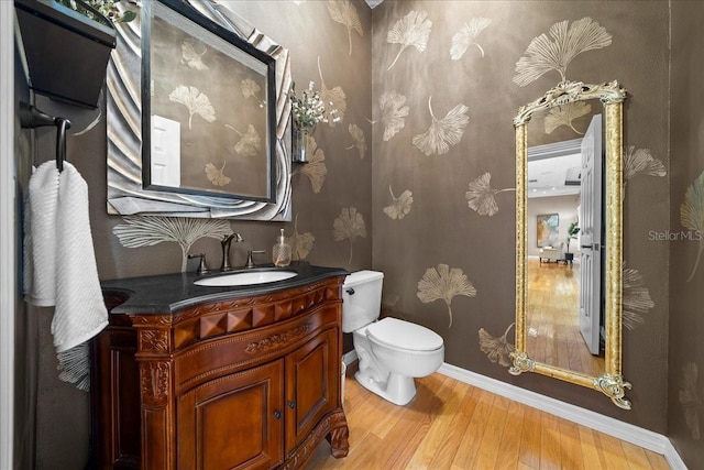 10044 Twelve Oaks Ct, Weeki Wachee, FL 34613 - bathroom featuring wood finished floors, toilet, vanity, and baseboards