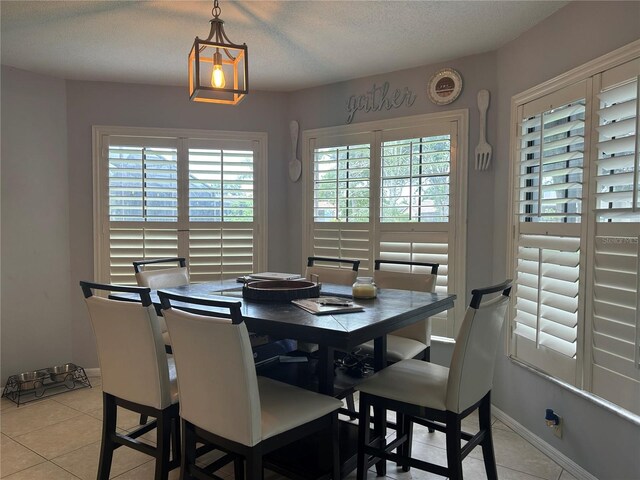 13316 Brigham Ln, Hudson, FL 34667 - dining room with light tile patterned floors, baseboards, and a textured ceiling