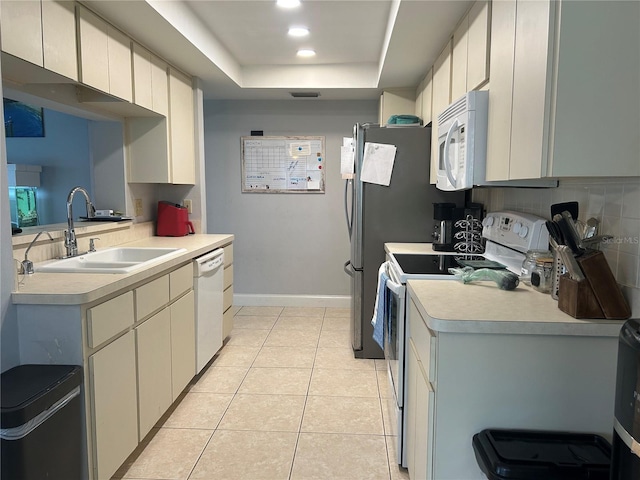 13316 Brigham Ln, Hudson, FL 34667 - kitchen with white appliances, a sink, a tray ceiling, light countertops, and decorative backsplash