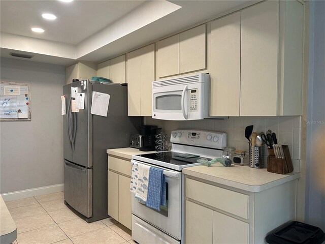 13316 Brigham Ln, Hudson, FL 34667 - kitchen featuring white appliances, light countertops, decorative backsplash, light tile patterned floors, and baseboards