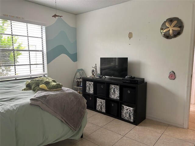 13316 Brigham Ln, Hudson, FL 34667 - bedroom with light tile patterned floors, baseboards, and a textured ceiling