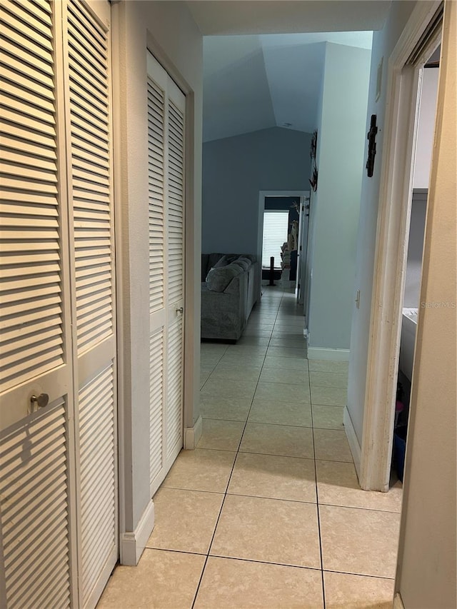 13316 Brigham Ln, Hudson, FL 34667 - hall with lofted ceiling, light tile patterned floors, and baseboards